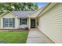 Inviting front entrance with a well-kept lawn and manicured flower beds at 615 Coan Dr, Locust Grove, GA 30248