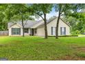 Traditional home boasts a well-maintained lawn with shade trees in a quiet neighborhood at 615 Coan Dr, Locust Grove, GA 30248