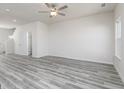 Open living room featuring light gray wood floors, neutral walls, and a modern ceiling fan at 493 Prescott Way, Villa Rica, GA 30180