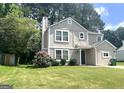 Classic two-story home with a lovely lawn and mature trees offering curb appeal and charm at 6300 Creekford Ln, Lithonia, GA 30058