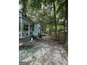 The overgrown backyard featuring building supplies and debris that needs cleaning up and some landscape maintenance at 8373 Chicago Ave, Douglasville, GA 30134