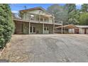 Two-story home featuring a large wooden deck, with lower-level access, and a covered parking area at 6220 Petersburg Rd, Fairburn, GA 30213