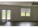 Bright living room features hardwood floors, a ceiling fan, a back yard view and access via glass doors at 1636 Jersey Dr, Stockbridge, GA 30281