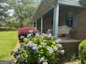 Inviting front porch of brick home with lovely landscaping and a cozy swing at 260 Willis Rd, Sharpsburg, GA 30277