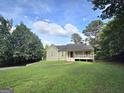 Inviting single-story home with a covered front porch and well-maintained lawn under a beautiful sky at 165 Cedar Ridge Rd, Locust Grove, GA 30248