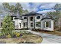 Stunning two-story brick home with a manicured lawn, a circular driveway, and modern gray accents at 4090 Sandy Lake Dr, Lithonia, GA 30038