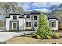 Stylish two-story home featuring a crisp white brick facade, dark trim, and mature landscaping at 4090 Sandy Lake Dr, Lithonia, GA 30038