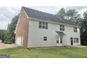 Back exterior of two-story home featuring siding and brick and an attached garage at 1433 Cotton Sw Trl, Conyers, GA 30094