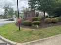 Manicured landscaping surrounds the community sign at Harrington Ridge in front of wooded area and other apartments at 14104 Fairington Ridge Cir, Lithonia, GA 30038