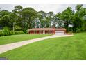 Red house showcasing a well-maintained lawn, leading to a welcoming entrance and attached garage at 125 Point View Ct, Tyrone, GA 30290