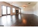 Spacious living room with a fireplace, ceiling fan, and dark hardwood floors at 335 Autumn Bluff Dr, Lawrenceville, GA 30044