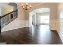 Open-concept living space featuring hardwood floors, chandelier, and elegant archway at 335 Autumn Bluff Dr, Lawrenceville, GA 30044