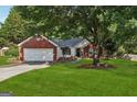 Inviting home with brick accents, a well-kept lawn, and mature trees providing shade at 905 Creekmore Ln, Loganville, GA 30052