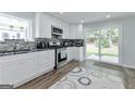 Bright kitchen with stainless steel appliances, white cabinets, and sliding glass doors leading to backyard at 4180 Pineset Dr, Alpharetta, GA 30022