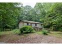 Exterior view of a home with a wood ramp surrounded by mature trees and shrubs at 400 Mccart Rd, Mcdonough, GA 30252
