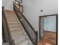 Carpeted staircase features a dark wooden handrail and decorative spindles leading to the upper level at 424 Browning Field Way, Hampton, GA 30228