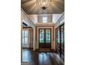 Elegant foyer featuring dark wood floors, a modern chandelier, and a clear view to the front yard at 6248 Sunshine Cove Ln, Buford, GA 30518