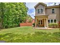 Beautiful backyard featuring a lush green lawn, privacy fence and covered patio perfect for relaxing and entertaining at 50 Star Spangled Ln, Peachtree City, GA 30269