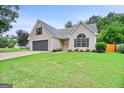 Well-maintained single-Gathering home with a lush green lawn and mature trees at 147 Calico Loop, Grantville, GA 30220