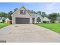 Inviting single-Gathering home with a long driveway leading to an attached garage at 147 Calico Loop, Grantville, GA 30220
