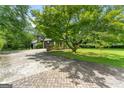 Spacious driveway leading to a charming home surrounded by lush greenery at 955 Landmark Dr, Sandy Springs, GA 30342