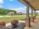 View from the charming front porch showcasing the neighborhood and lush landscaping at 149 Elkins Blvd, Locust Grove, GA 30248