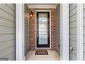 Inviting front entrance with brick accents, a glass-paneled door, and a welcoming doormat at 3511 Brockenhurst Dr, Buford, GA 30519