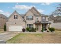 Charming two-story brick home boasts a two-car garage, manicured lawn, and inviting front porch at 3225 Alhambra Cir, Hampton, GA 30228