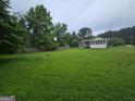 Expansive backyard featuring lush green grass and a screened-in porch area at 1997 Villa Rica Hwy, Dallas, GA 30157