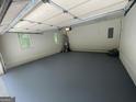 The garage features newly painted flooring, offering a clean and functional space for parking and storage at 56 Ridgewood Ct, Mcdonough, GA 30252