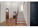 Elegant foyer showcasing hardwood floors, staircase, and natural light at 4595 Carriage Walk Ln, Cumming, GA 30040