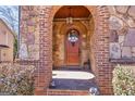A gorgeous solid wood arched front door with brick and stone entryway at 4595 Carriage Walk Ln, Cumming, GA 30040