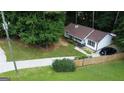An aerial view of a well-maintained home with a fenced yard and long driveway in a wooded setting at 85 Pine Haven Dr, Carrollton, GA 30116