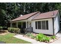 Charming single-story home featuring a covered front porch, walkway, and landscaped garden at 85 Pine Haven Dr, Carrollton, GA 30116