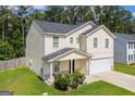 Side view of a two-story home with attached garage and well-manicured lawn at 411 Hopi Ln, Villa Rica, GA 30180