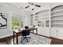 Well-lit home office with built-in shelving, a wooden desk, and patterned rug at 1220 Roswell Manor Cir, Roswell, GA 30076