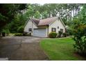 View of home's side and backyard, with a driveway and mature trees at 640 Keys Ferry Rd, Mcdonough, GA 30252
