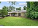 Charming single-story home with a well-manicured lawn and mature trees providing shade at 962 Brighton Dr, Lawrenceville, GA 30043