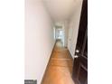 Long hallway with white walls, door and a dark accent door at 11598 E Lovejoy Rd # 3, Hampton, GA 30228