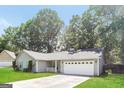 Traditional home with a two-car garage, white trim, and a well-kept front yard at 1421 Oak Knoll Ne Dr, Conyers, GA 30012