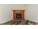 Inviting living room with a brick fireplace and wood-look flooring at 1421 Oak Knoll Ne Dr, Conyers, GA 30012