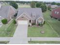 Aerial view of a brick home showcasing its driveway, landscaping, and proximity to the surrounding neighborhood at 3368 Alhambra Cir, Hampton, GA 30228