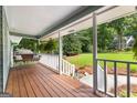 Relaxing front porch with wooden swing, wooden floors, and white railings at 431 Hampton Grn, Peachtree City, GA 30269