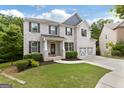 Charming two-story brick home featuring a well-manicured lawn, a two-car garage, and black shutters at 2307 Loughridge Dr, Buford, GA 30519
