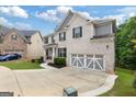 Charming two-story brick home featuring a well-manicured lawn, a two-car garage, and black shutters at 2307 Loughridge Dr, Buford, GA 30519