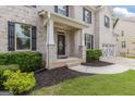 Inviting front porch of a brick home with a covered entrance and manicured landscaping at 2307 Loughridge Dr, Buford, GA 30519