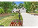 Landscaped front yard with white home, brown accents, and a long driveway leading to the attached two-car garage at 4210 Platinum Ct, Hoschton, GA 30548