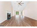 Spacious living room with hardwood floors, a fireplace, high ceiling and large windows allowing natural light at 4210 Platinum Ct, Hoschton, GA 30548