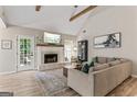 Spacious living room with beamed, vaulted ceiling, fireplace, and wood-look flooring at 15 Stonewood Way, Sharpsburg, GA 30277