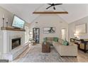 Inviting living room offering vaulted ceilings, wood beam detail, and cozy fireplace at 15 Stonewood Way, Sharpsburg, GA 30277